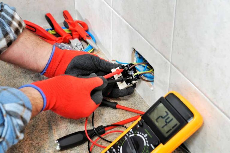 Electrician With Gloves Measuring The Voltage Of A Wire